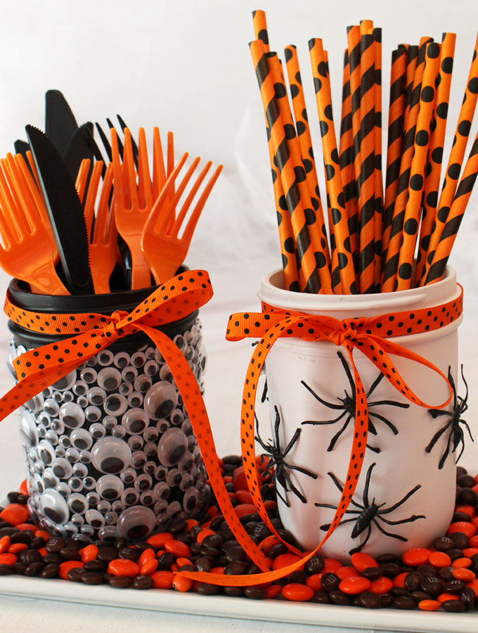 Spooky Halloween Mason Jars - a fun diy Halloween craft project to do with the kids. Cover Mason Jars with creeping, crawling spiders and jiggly Monster Eyes and you have a Halloween container that will look great on your Halloween Party food table! Pin this cute Halloween Party Idea for later and follow us for more fun Halloween Decoration Ideas.