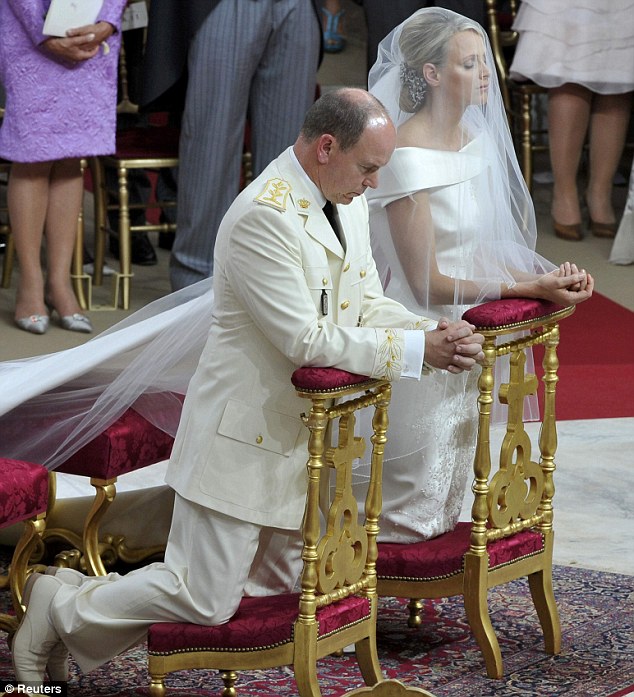 Let us pray: The couple kneel at the altar during their service