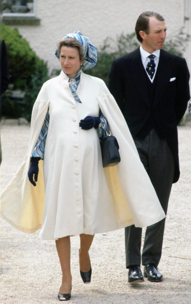 Princess Anne appeared radiant in this timeless ensemble while pregnant with her second child, Zara Phillipss. While attending a spring wedding just weeks ahead of her due date in 1981, the pregnant royal donned a timeless, cream-colored cape that complemented her blue and white printed dress underneath. She pulled the rest of her look together with a matching head scarf, black leather handbag and a delicate pair of gloves.