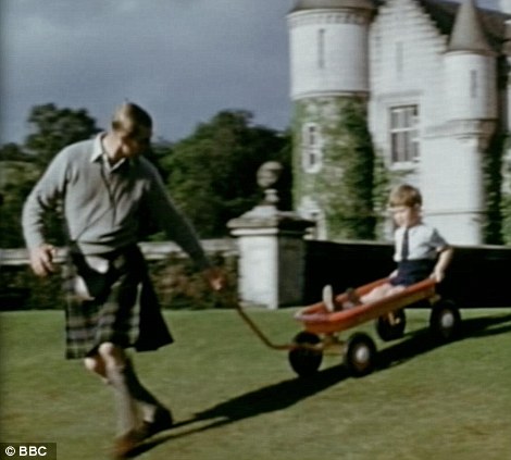 A young Prince Charles plays with his toy wagon