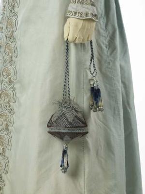 (Matching reticule detail) A pelisse or pelisse-coat, a kind of women's outer garment which could be made in everything from the lightest silk to heavy fur. It was worn over a gown but could look like a gown itself, especially when floor length like this garment. The pelisse was made for a trousseau in 1823 for the wedding of the grandmother of the donor.: 