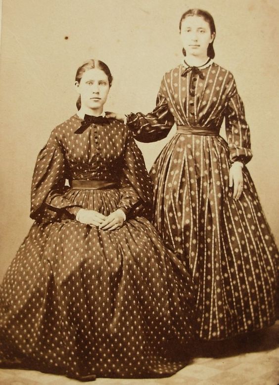 Young women wearing pretty calico dresses.