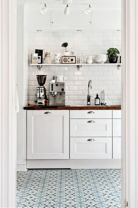 Blue printed tiles in white modern rustic kitchen, white cabinets, open shelving, butcher block counters and white subway tile: 