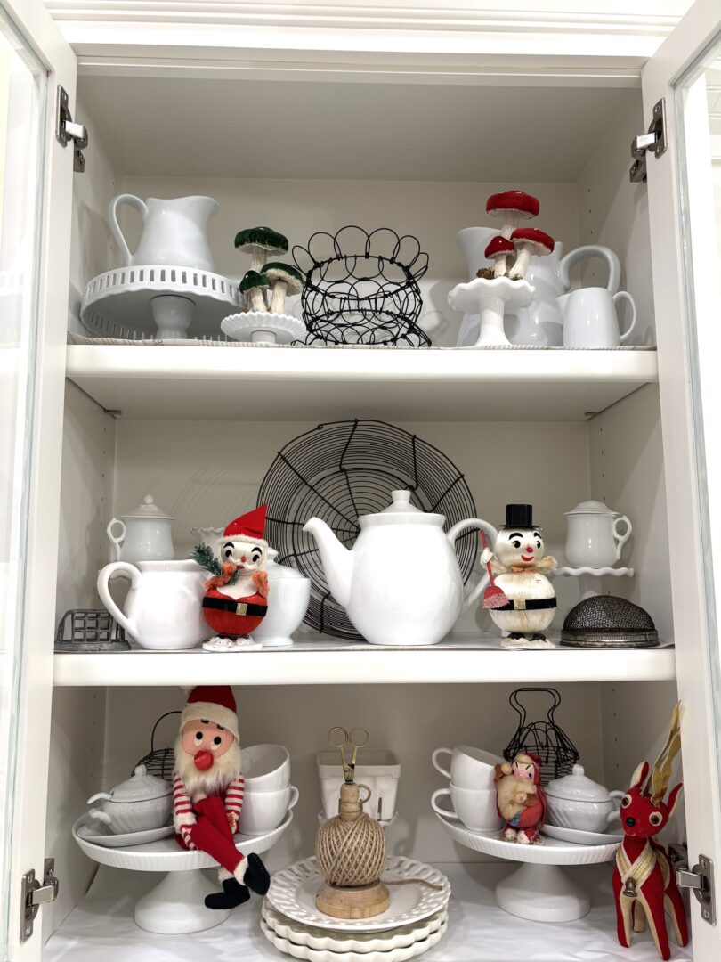 Kitchen cabinet full of vintage Christmas decor.