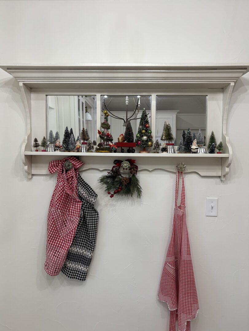 White shelf with small bottle brush Chrismas trees.